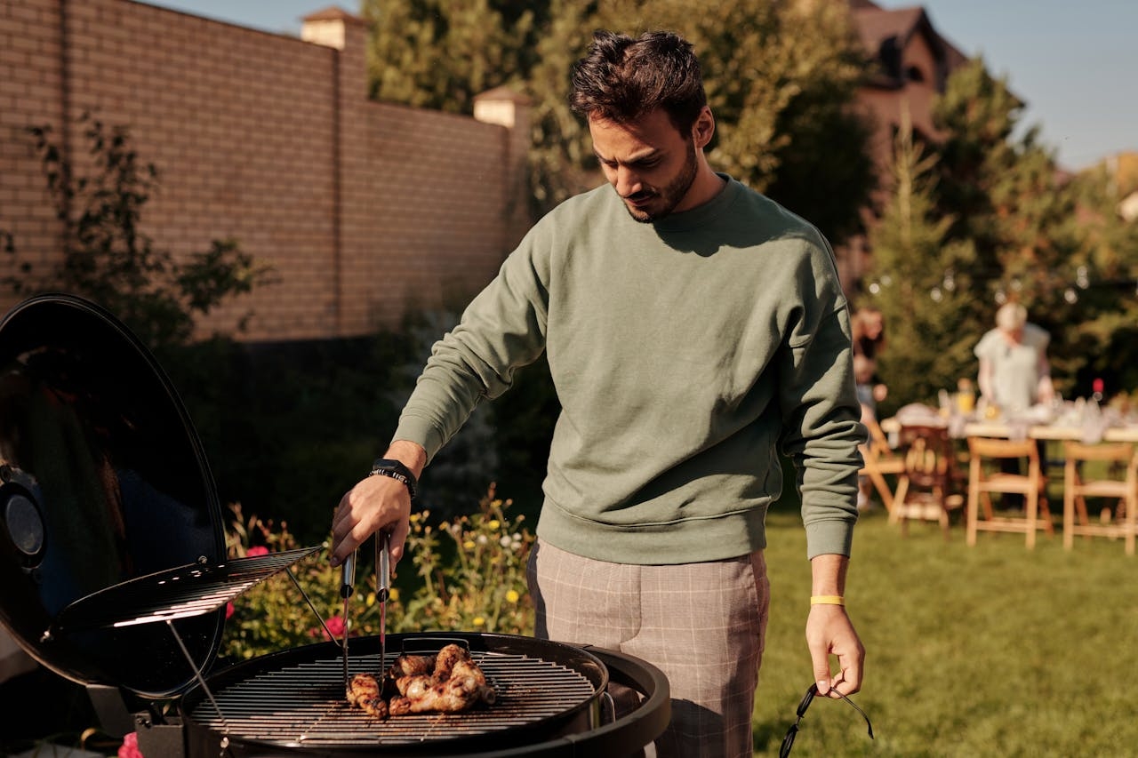 man grillar på kolgrill